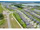 This aerial shows a community with homes situated near green spaces and water features at 9324 Rally Spring Loop, Wesley Chapel, FL 33545