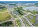 An expansive aerial view showcases a community with houses, lakes, and green spaces at 9324 Rally Spring Loop, Wesley Chapel, FL 33545