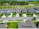 Aerial view showcasing a well-maintained neighborhood with neatly arranged homes, manicured lawns, and tree-lined streets at 9324 Rally Spring Loop, Wesley Chapel, FL 33545