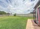 Lush backyard with a well-maintained lawn, bordered by a white fence, offering a private outdoor space for recreation at 9324 Rally Spring Loop, Wesley Chapel, FL 33545