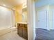 Well-lit bathroom with white tiled shower-tub, modern vanity, and convenient access to the hall at 9324 Rally Spring Loop, Wesley Chapel, FL 33545