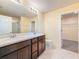 Bathroom featuring a double vanity and glass shower at 9324 Rally Spring Loop, Wesley Chapel, FL 33545