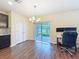 Sunlit dining area with a stylish chandelier, sliding glass doors to the patio, and a convenient workspace at 9324 Rally Spring Loop, Wesley Chapel, FL 33545