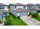 Side view of a well-maintained home with a two-car garage and lush green lawn at 9324 Rally Spring Loop, Wesley Chapel, FL 33545