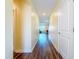 Long hallway with wood flooring and a view into the living area with natural light at 9324 Rally Spring Loop, Wesley Chapel, FL 33545