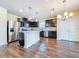 Spacious kitchen with stainless steel appliances, dark cabinetry, island, and hardwood floors at 9324 Rally Spring Loop, Wesley Chapel, FL 33545