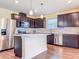 Modern kitchen boasts stainless steel appliances, dark cabinets, a center island, and stylish pendant lighting at 9324 Rally Spring Loop, Wesley Chapel, FL 33545