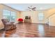 Spacious living room with wood floors, large windows, and ceiling fan provides ample space at 9324 Rally Spring Loop, Wesley Chapel, FL 33545