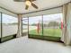 Cozy screened porch with ceiling fan, curtains, and views of the backyard, ideal for outdoor relaxation and entertainment at 9324 Rally Spring Loop, Wesley Chapel, FL 33545