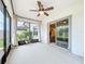 Inviting screened porch with neutral decor, ceiling fan, and sliding door, perfect for relaxing and enjoying the outdoors at 9324 Rally Spring Loop, Wesley Chapel, FL 33545