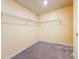 A compact walk-in closet fitted with wire shelving on two walls and cozy carpeting that provides ample storage space at 9324 Rally Spring Loop, Wesley Chapel, FL 33545