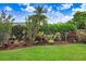 Lush backyard landscape featuring manicured lawn and colorful foliage for privacy at 10231 Millport Dr, Tampa, FL 33626