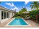 Inviting backyard pool surrounded by lush landscaping and a brick patio with chaise lounges at 10231 Millport Dr, Tampa, FL 33626