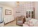 Bedroom with a pink gingham accent wall, gold crib and chandelier, plus lots of natural light at 10231 Millport Dr, Tampa, FL 33626