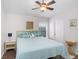 Bedroom featuring neutral walls, wood floors, ceiling fan, and a bright window offering natural light at 10231 Millport Dr, Tampa, FL 33626