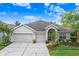 Charming single-story home with a three-car garage, mature landscaping, and inviting curb appeal at 10231 Millport Dr, Tampa, FL 33626