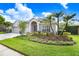 Attractive single-story home with a three-car garage, arched entryway, and verdant front yard at 10231 Millport Dr, Tampa, FL 33626