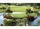 Beautiful island green on the golf course surrounded by tropical landscaping and serene water features at 10231 Millport Dr, Tampa, FL 33626