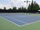 Outdoor tennis court with well-maintained surface and lighting, perfect for recreational play at 10231 Millport Dr, Tampa, FL 33626