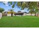 Expansive backyard featuring a lush lawn, mature trees, and a well-maintained exterior with a screened-in patio at 10701 Glen Ivy Ln, Tampa, FL 33624