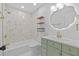 Charming bathroom featuring vintage style vanity, modern lighting, and tiled shower at 10701 Glen Ivy Ln, Tampa, FL 33624