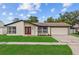 Charming single-story home boasts a lush lawn, red front door and attached garage in a suburban neighborhood at 10701 Glen Ivy Ln, Tampa, FL 33624
