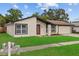 Charming single-story home featuring a well-manicured lawn, colorful landscaping, and attached two-car garage at 10701 Glen Ivy Ln, Tampa, FL 33624
