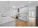 Well-lit kitchen featuring white cabinets, modern appliances, a spacious countertop, and a hardwood floor at 10701 Glen Ivy Ln, Tampa, FL 33624