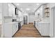 Modern kitchen with white cabinets, stainless steel appliances, stone backsplash, and hardwood floors at 10701 Glen Ivy Ln, Tampa, FL 33624