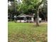 Inviting single-story home featuring a cozy porch and a serene front yard with mature trees at 118 W 122Nd Ave, Tampa, FL 33612