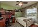 Bedroom with stone accent wall, ceiling fan, desk, and a large window letting in natural light at 1250 S Pinellas Ave # 214, Tarpon Springs, FL 34689