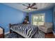 Stylish bedroom with vibrant blue walls, ceiling fan, and private balcony access at 1250 S Pinellas Ave # 214, Tarpon Springs, FL 34689
