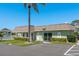 Exterior community building with a pool, green landscape, and an adjacent parking lot at 1250 S Pinellas Ave # 214, Tarpon Springs, FL 34689