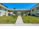 Charming condo building with lush landscaping, white railings, and a welcoming entrance at 1250 S Pinellas Ave # 214, Tarpon Springs, FL 34689