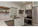 Modern kitchen featuring stainless appliances, granite counters, and open shelving at 1250 S Pinellas Ave # 214, Tarpon Springs, FL 34689