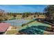 Aerial view of community tennis and basketball courts, surrounded by trees and golf course at 12705 Green Heron Way, Odessa, FL 33556