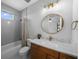 Bathroom features wood vanity, decorative mirror, bathtub with shower, and white tiled floor at 12705 Green Heron Way, Odessa, FL 33556