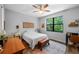 Cozy bedroom features a ceiling fan, a large window view, and hardwood floors at 12705 Green Heron Way, Odessa, FL 33556