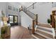 Bright and open entryway with wood floors, modern staircase, and black entry door at 12705 Green Heron Way, Odessa, FL 33556