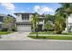 Beautiful two-story home featuring a well-manicured lawn, brick driveway, and palm trees at 12705 Green Heron Way, Odessa, FL 33556