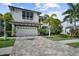Stunning two-story home with a paver driveway, lush landscaping, and a modern architectural design at 12705 Green Heron Way, Odessa, FL 33556