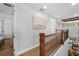 Upstairs hallway with wood floors, wood and metal railing, and transom windows at 12705 Green Heron Way, Odessa, FL 33556