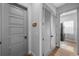 View of hallway leading to laundry room featuring a five panel light gray door and a closet with louvered doors at 12705 Green Heron Way, Odessa, FL 33556