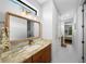 Hallway showcasing a vanity, mirror, decor, lights, and tile floor at 12705 Green Heron Way, Odessa, FL 33556