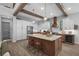 Modern kitchen boasts an island, wooden beams, and stainless steel appliances, perfect for entertaining at 12705 Green Heron Way, Odessa, FL 33556
