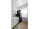 Well lit laundry room with stackable washer and dryer, white cabinets, and a utility sink at 12705 Green Heron Way, Odessa, FL 33556
