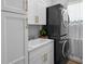 Modern laundry room with stacked washer and dryer, cabinets, and sink at 12705 Green Heron Way, Odessa, FL 33556
