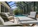 Screened-in pool area with outdoor seating and lush tropical landscaping at 12705 Green Heron Way, Odessa, FL 33556