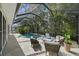 Enclosed pool area with waterfall feature, poolside seating, and beautiful landscaping at 12705 Green Heron Way, Odessa, FL 33556