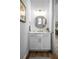 Elegant powder room with a round mirror, granite countertops, and gold accents at 12705 Green Heron Way, Odessa, FL 33556